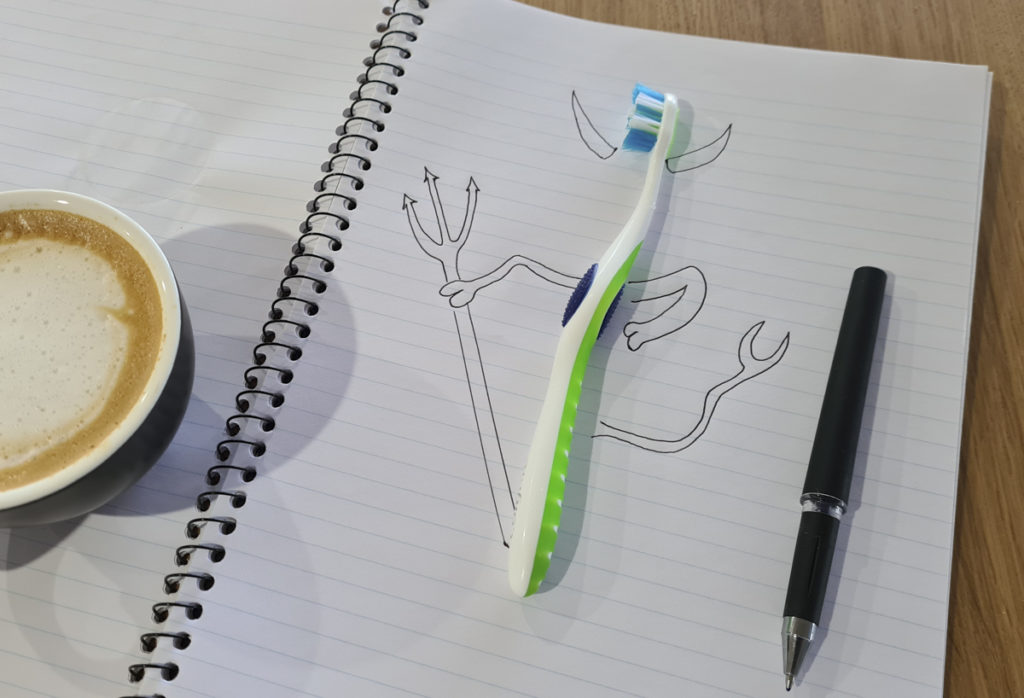 Toothbrush with hand drawn horns on notebook