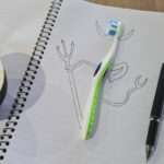 Toothbrush with hand drawn horns on notebook