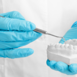 Dentist hands holding tooth mold