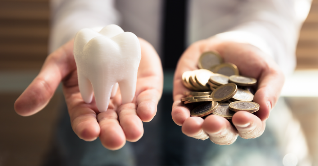 Close-up of a person's hand holding white tooth and coins