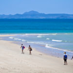 Two couples walk on an ideal beach on Keppel Island, Queensland, Australia.