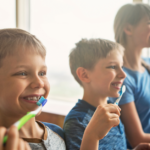 Three kids brushing teeth together.