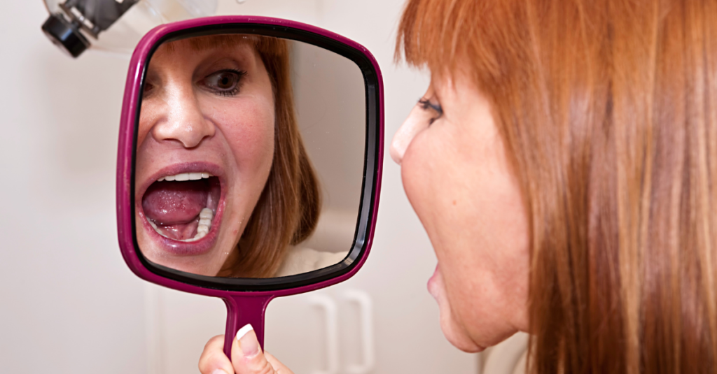 Woman at dentist office looking at her new dental implants.