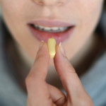 Person taking a pill.