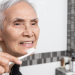 Happy healthy elderly person brushing their teeth.