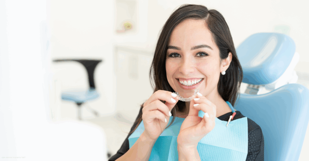 person at a dental office holding up clear aligners to her mouth